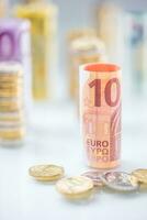 enrolado euro notas e moedas torres empilhado dentro de outros posições foto