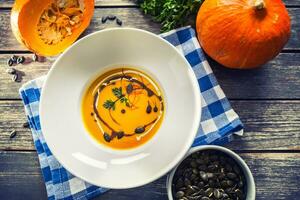 abóbora creme sopa com sementes e salsinha em cozinha mesa foto