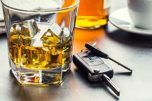 carro chaves e vidro do álcool em mesa. foto