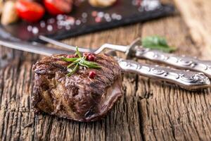 grelhado carne bife com alecrim, sal e Pimenta em velho corte borda. carne filé mignon bife. foto