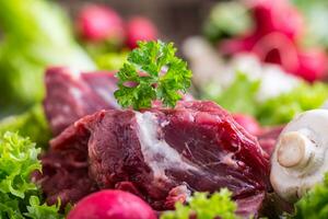 cru carne carne com fresco vegetal. fatiado carne bife dentro alface saladas rabanetes e cogumelos. foto