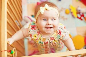 uma bebê menina é sorridente dentro dela berço foto