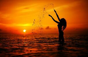 mulher na praia durante o pôr do sol foto