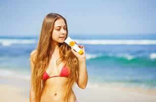 uma mulher dentro uma bikini é segurando a laranja escova de dente foto