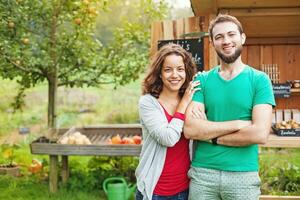 uma casal em pé dentro frente do uma jardim galpão foto