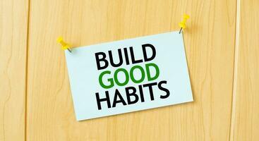 Construir Boa hábitos placa escrito em pegajoso Nota fixado em de madeira parede foto