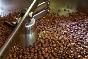 grãos de café em máquinas de torrefação de café foto