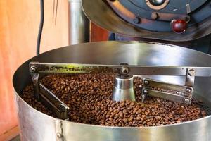 grãos de café em máquinas de torrefação de café foto