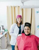 retrato do dentista com paciente sorridente às Câmera dentro escritório, fêmea dentista com satisfeito paciente sorridente às Câmera, fêmea dentista com paciente sorridente amigáveis foto