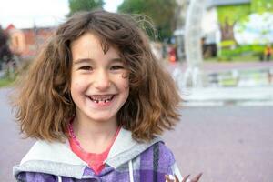 desdentado feliz sorrir do uma menina com uma caído mais baixo leite dente fechar-se. mudando dentes para Molares dentro infância foto