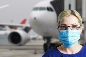 mulher dentro protetora mascarar em a fundo do a avião. cancelado ar Serviços vencimento para uma coronavírus epidemia foto