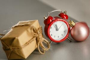 vintage alarme relógio com Natal presente e luzes em fundo foto