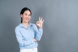 jovem mulher asiática sorrindo e mostrando sinal de ok foto