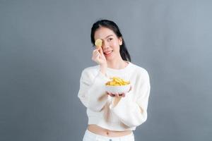 jovem mulher asiática come batata frita foto