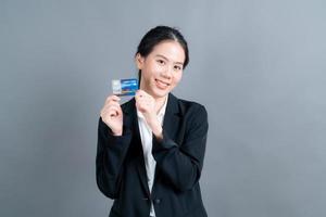 retrato de uma adorável jovem asiática mostrando cartão de crédito foto