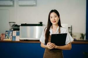 comece bem sucedido pequeno o negócio proprietário sme mulher ficar de pé com tábua dentro cafeteria. mulher barista cafeteria proprietário. foto