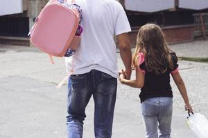 pai levando a filha para a escola com espaço de cópia