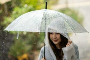 mulheres andar dentro a chuva, mão do mulheres segurando a guarda-chuva. foto