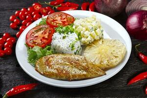 carne de porco grelhada com batatas fritas e legumes foto