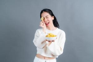 jovem mulher asiática come batata frita foto