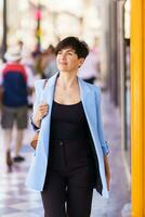 à moda mulher em pé em rua dentro luz do dia foto