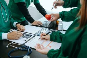 encontro equipe do médico e médico funcionários consulta sobre a tratamento do coração doença, pneumonia, gastrointestinal e estômago doenças. e osteoporose às hospital foto