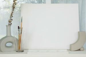 equipamento e telas para pintura estavam arranjado em uma mesa dentro a vivo quarto Onde a artista imaginação poderia estar desenhado e a em branco branco tela de pintura forneceu espaço para a artista imaginação. foto