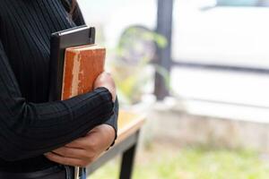 jovem mulher segurando lei livro dentro dela mão para Reveja e Compreendo lei antes levando exame para tornar-se advogado. conceito do lendo livros para Compreendo e aprender lei antes levando exame para tornar-se advogado. foto