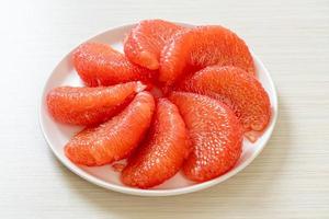 pomelo vermelho fresco ou toranja no prato foto