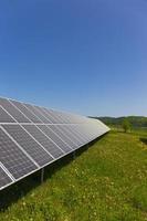 estação de energia solar no prado florido de verão foto