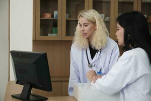 dois profissional médico equipes, ásia fêmea doutor, e branco farmacêutico discutido tratamento remédio prescrições às contador do a farmacia departamento dentro hospital clínica. foto