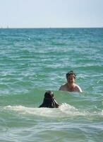 baixo ângulo Visão do pessoas quem estão desfrutando verão quente dia às bournemouth de praia do Inglaterra, ótimo bretanha. Reino Unido. agosto 23, 2023 foto