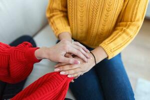 fechar-se tiro do dois irreconhecível pessoas segurando mãos dentro conforto. estar a pessoa quem ajuda a próximo. eu sou aqui para você. cortada tiro do dois irreconhecível pessoas segurando mãos foto