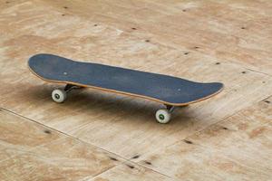 um skate em uma rampa de piso de madeira foto
