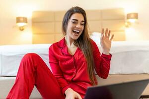 lindo mulher trabalhador autonomo anotando em formação para planejamento projeto fazendo controlo remoto trabalho através da computador portátil computador. rindo enquanto lendo o email em moderno computador portátil dispositivo . foto