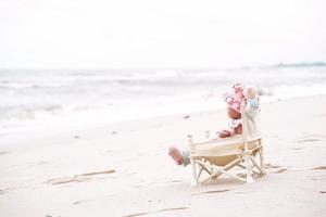 menina asiática sentada na cadeira de praia. foto