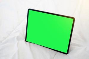vista superior do tablet preto em uma cama com chave croma verde.