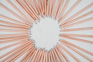 lápis de madeira dispostos em um círculo na mesa branca. foto