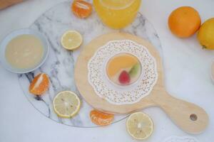 fruta geléia com laranja suco, limão e kiwi em a mesa foto