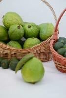 fresco goiaba fruta dentro uma cesta em branco fundo. seletivo foco. foto