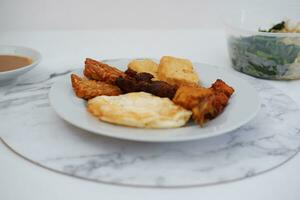 frito tofu com frito ovo e amendoim molho em branco mármore mesa foto