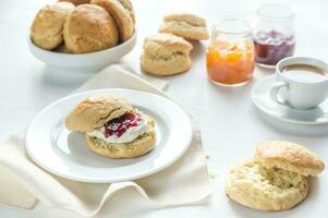 scones com creme e fruta geléia e copo do café foto