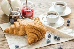 croissants com copos do café e leite foto