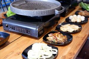 grade panela com grelhado carne de porco e dumplings em de madeira mesa foto