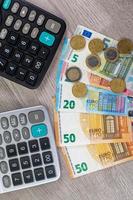 dinheiro em euros de diferentes denominações e calculadoras