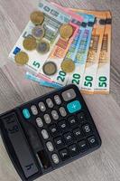 dinheiro em euros de diferentes denominações e calculadora foto