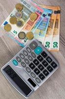 dinheiro em euros de diferentes denominações e calculadora foto