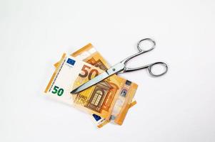 corte notas de 50 euros com uma tesoura foto