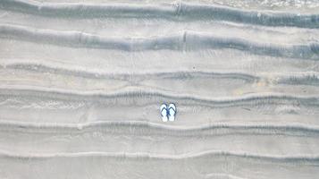 chinelos na praia de areia, plano de fundo das férias de verão, vista aérea de cima