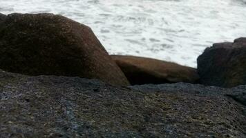 Visão do a ondas e pedras em a de praia foto